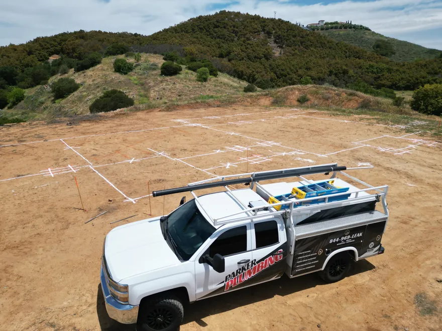 Parker Plumbing service truck on a graded new-construction lot in the Temecula Valley hills